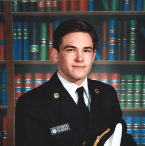 A young man wearing a captains uniform smiling